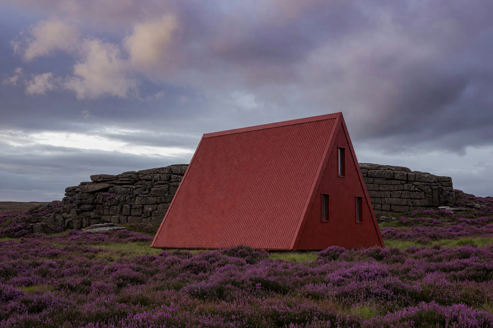 Concept visualisation, not a photograph: oxide red, on the moor in corrugated powder-coated steel.