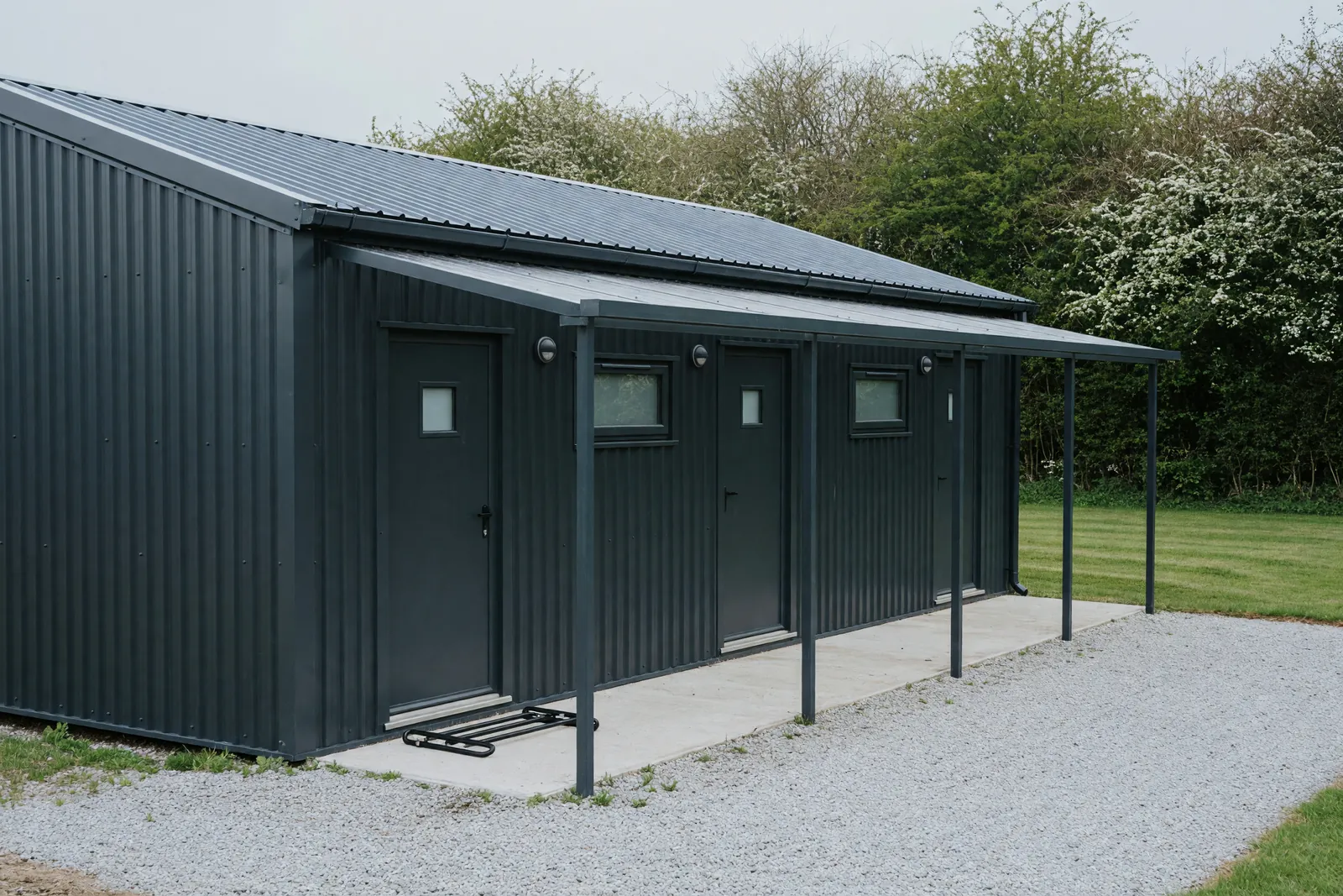 Concept visualisation, not a photograph: amenity block in corrugated powder-coated steel.