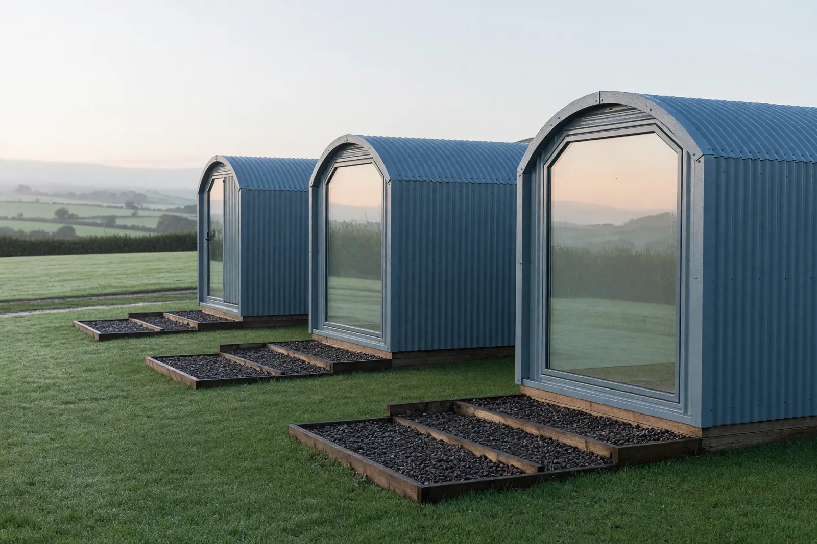 Concept visualisation, not a photograph: sleeping pod row in corrugated powder-coated steel.